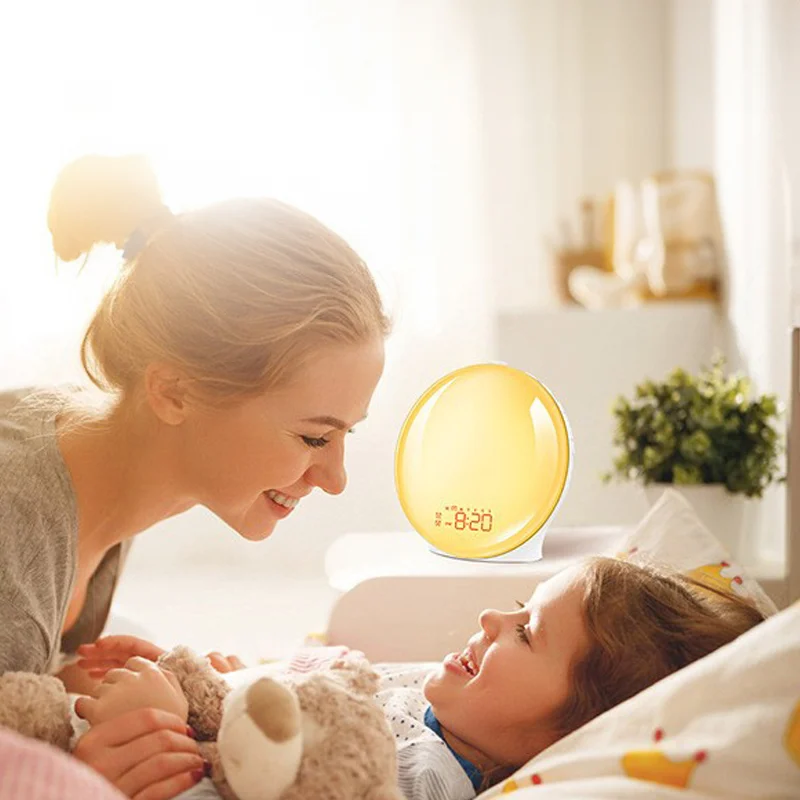 Moeder en kind in bed, met de wekkerlamp in warm ochtendlicht op het nachtkastje