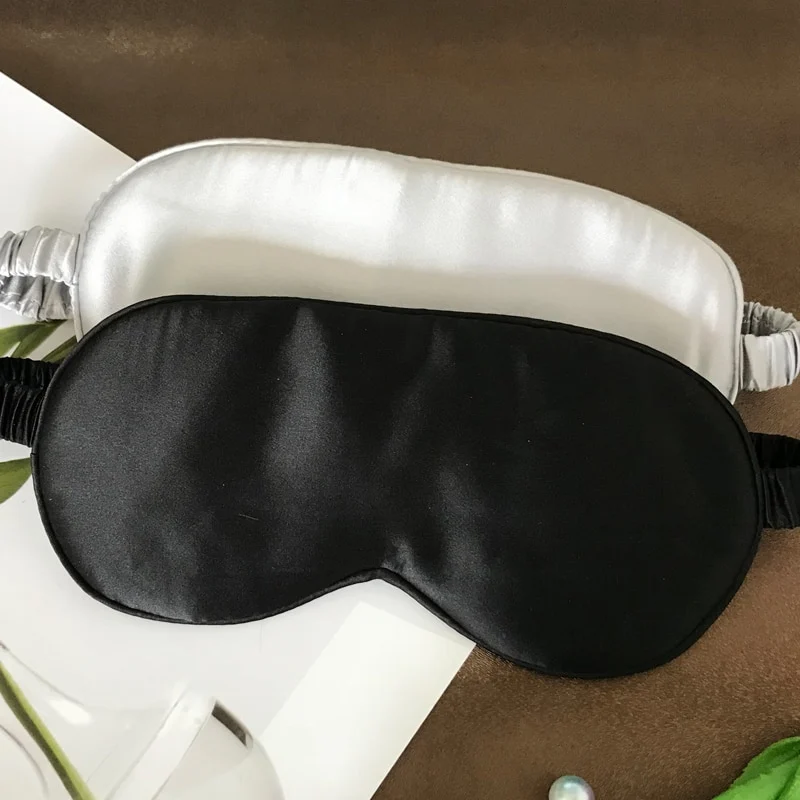 Zilvergrijs en zwart slaapmasker naast elkaar